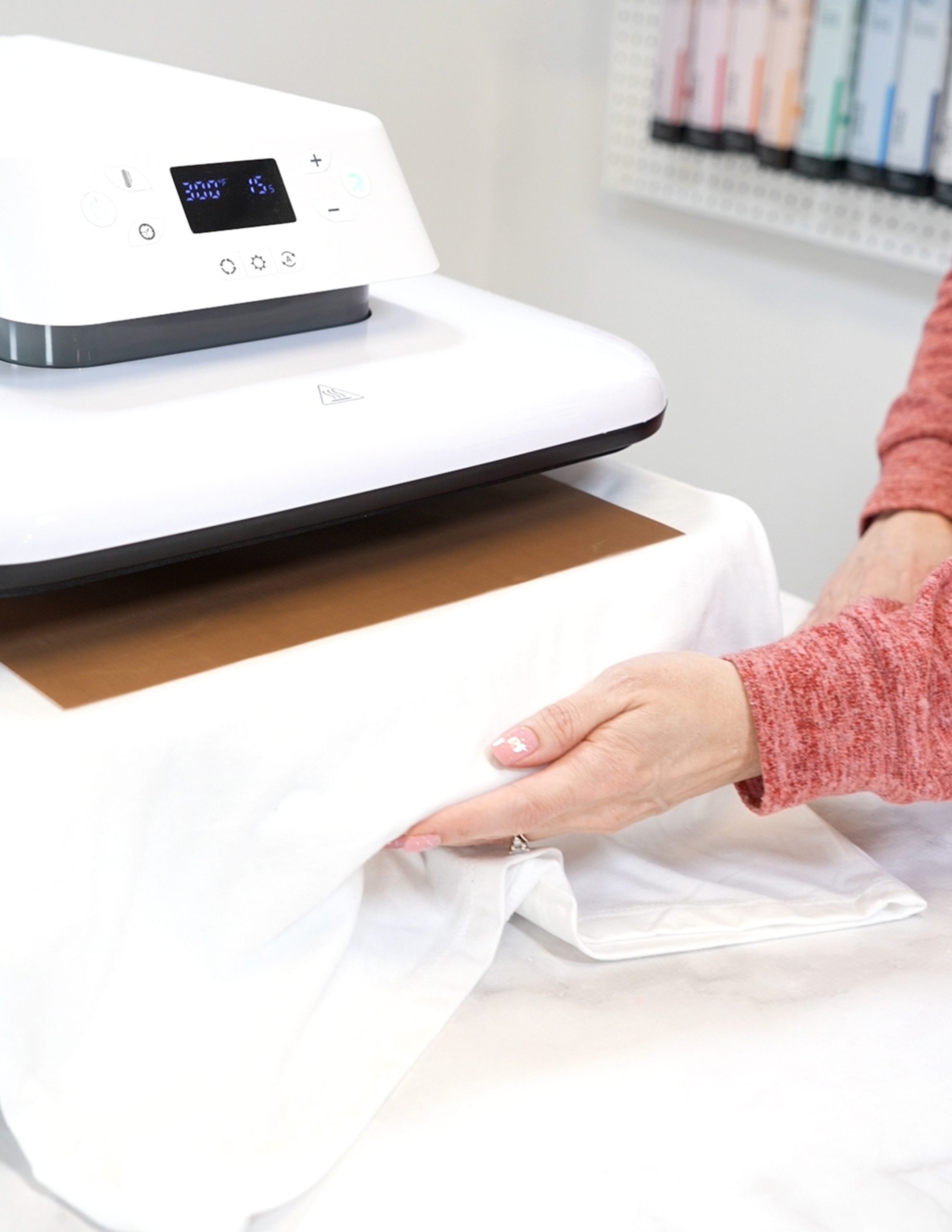 Hands closing the pullout drawer on the HTVRONT Auto Heat Press