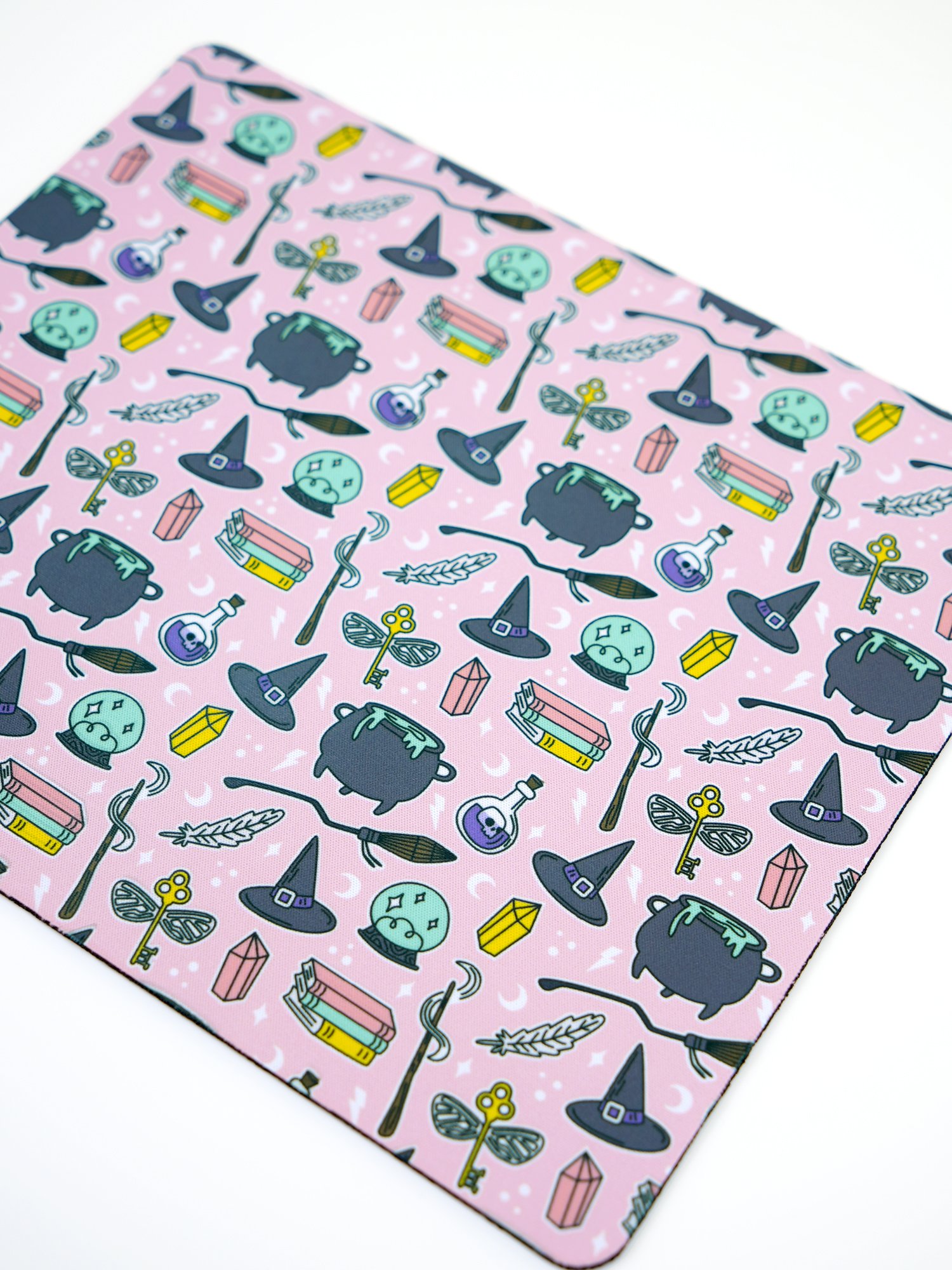 Close up of pink sublimated mouse pad with wizard icons and motifs