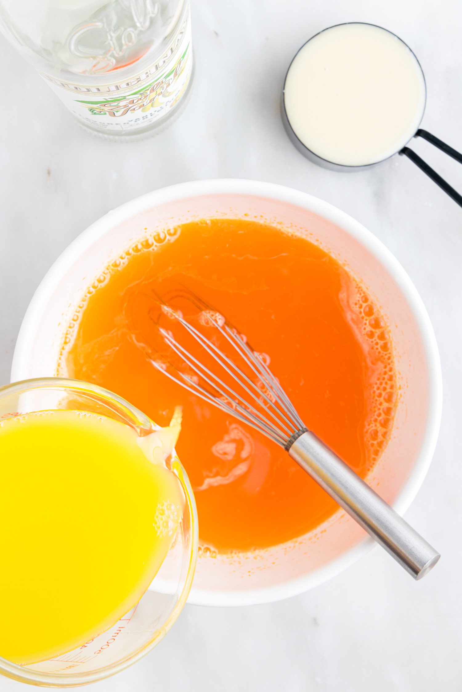 adding ingredients to mixing bowl for jello shots