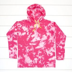 Hot pink bleach tie-dyed hoodie on a white wood background