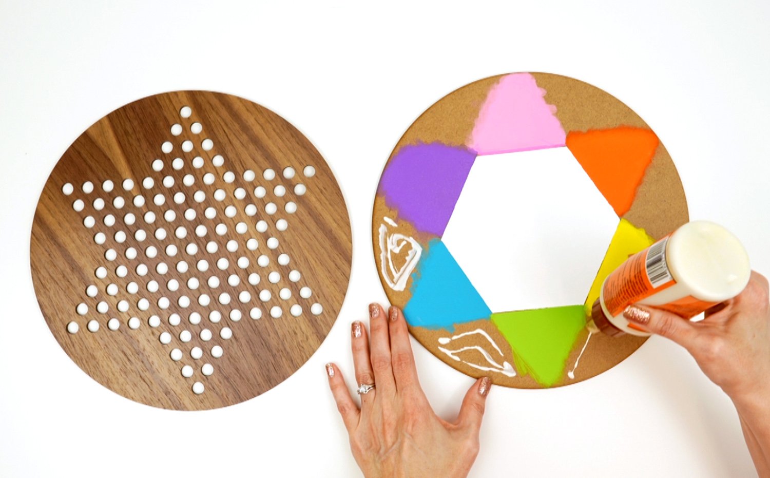 Hands applying wood glue to a sheet of MDF that has been painted for a Chinese checkers game board backing