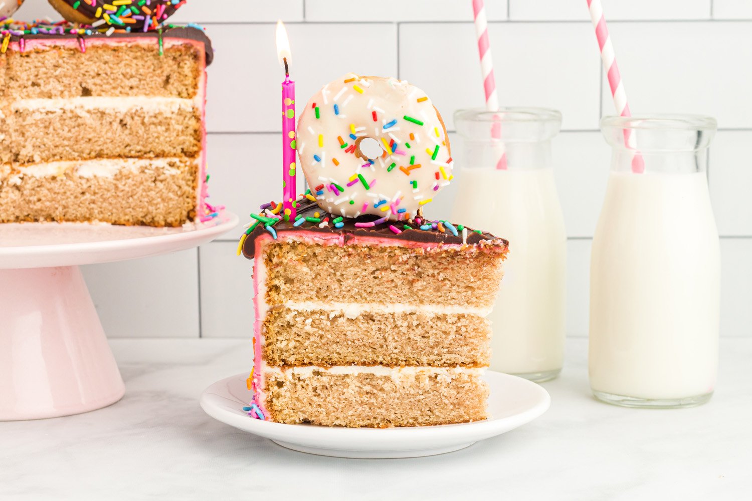 sprinkled donut birthday cake with lit candle