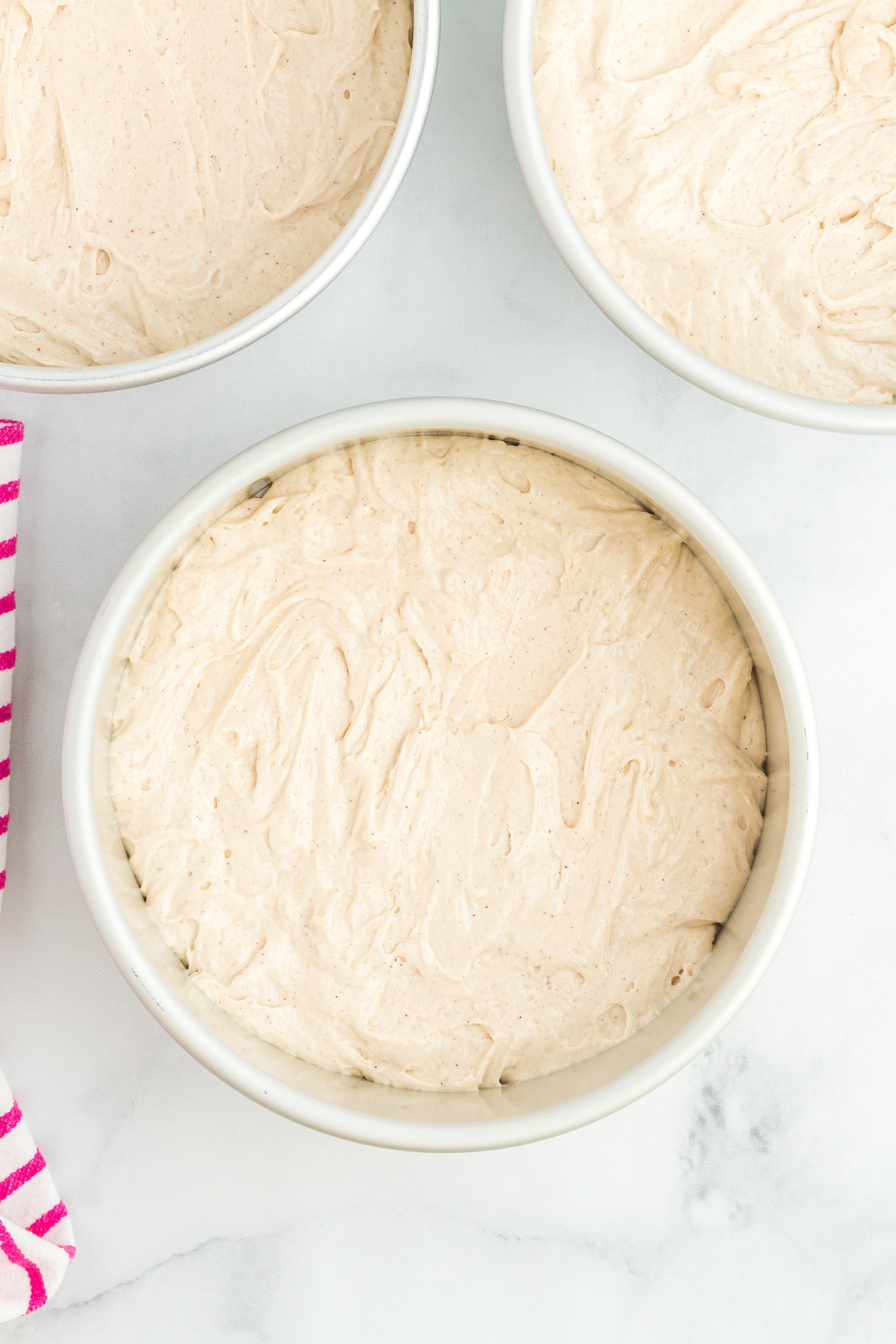 cake batter added to round cake pans for baking