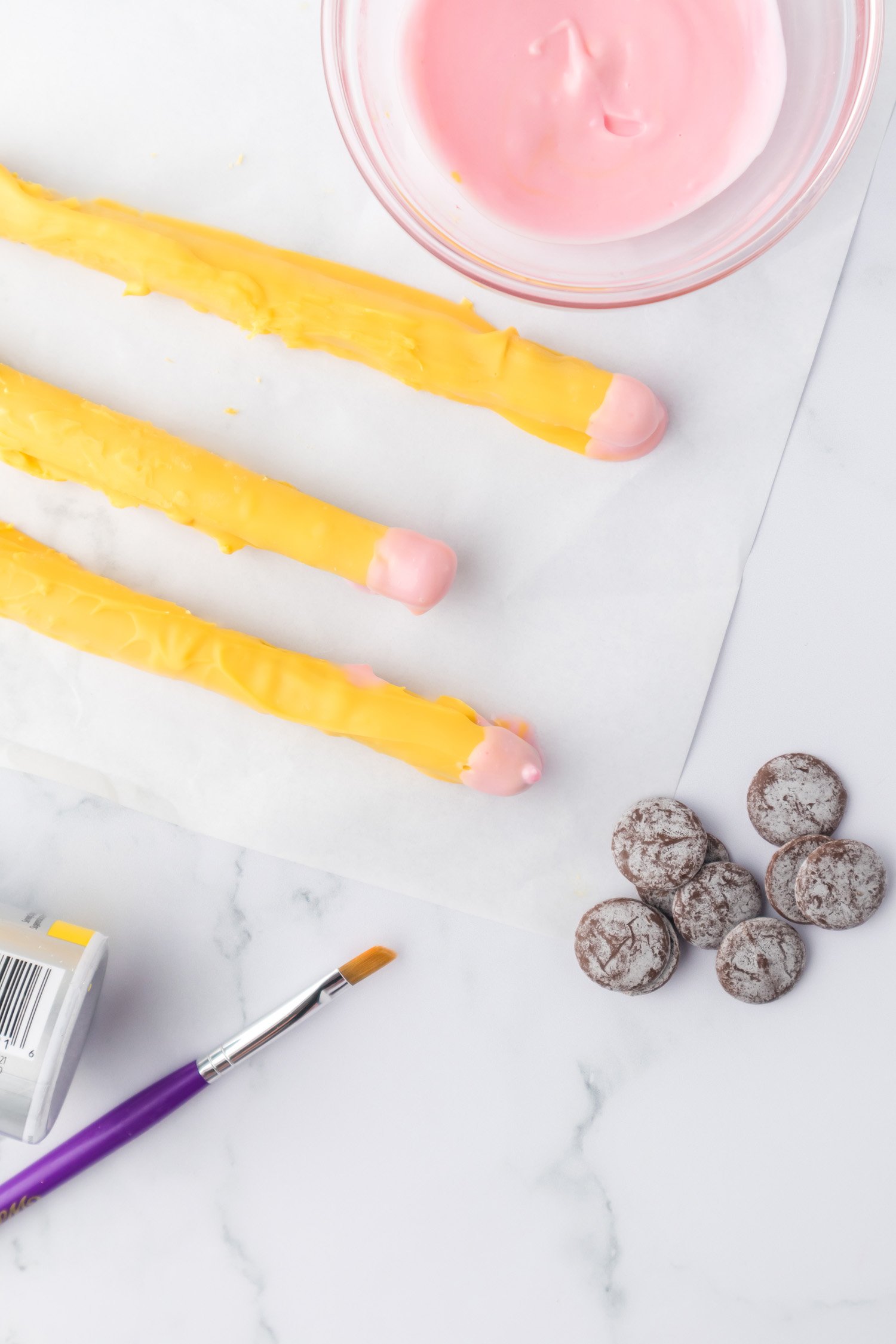 paint brushes and chocolate next to chocolate covered pretzel pencils