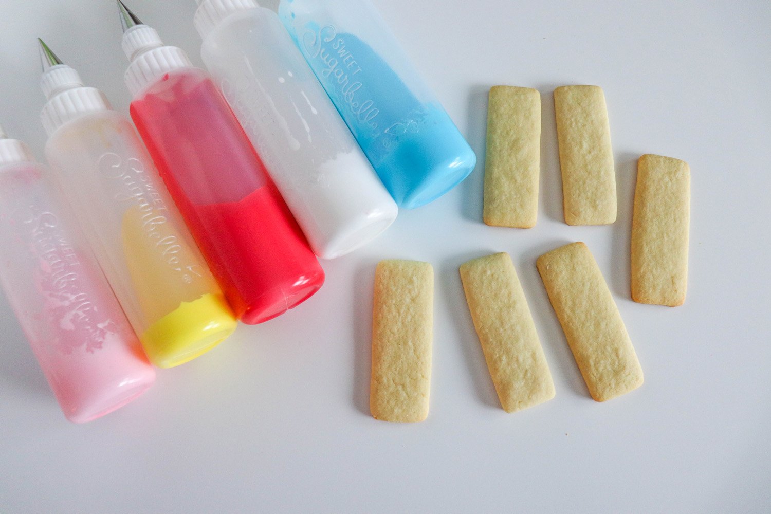 cut out sugar cookies and icing color bottles