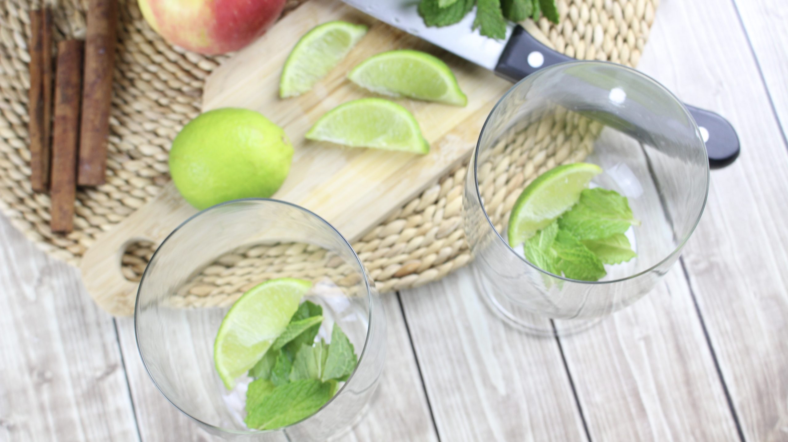 cocktail glasses with sliced lime wedges and mint