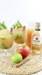 rum, apple cider and whole apples next to mojito drinks