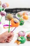 hand holding up decorated monster cake pops