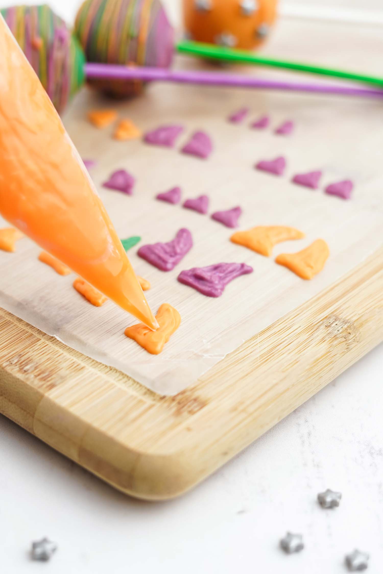 piping bag piping monster horns onto parchment paper