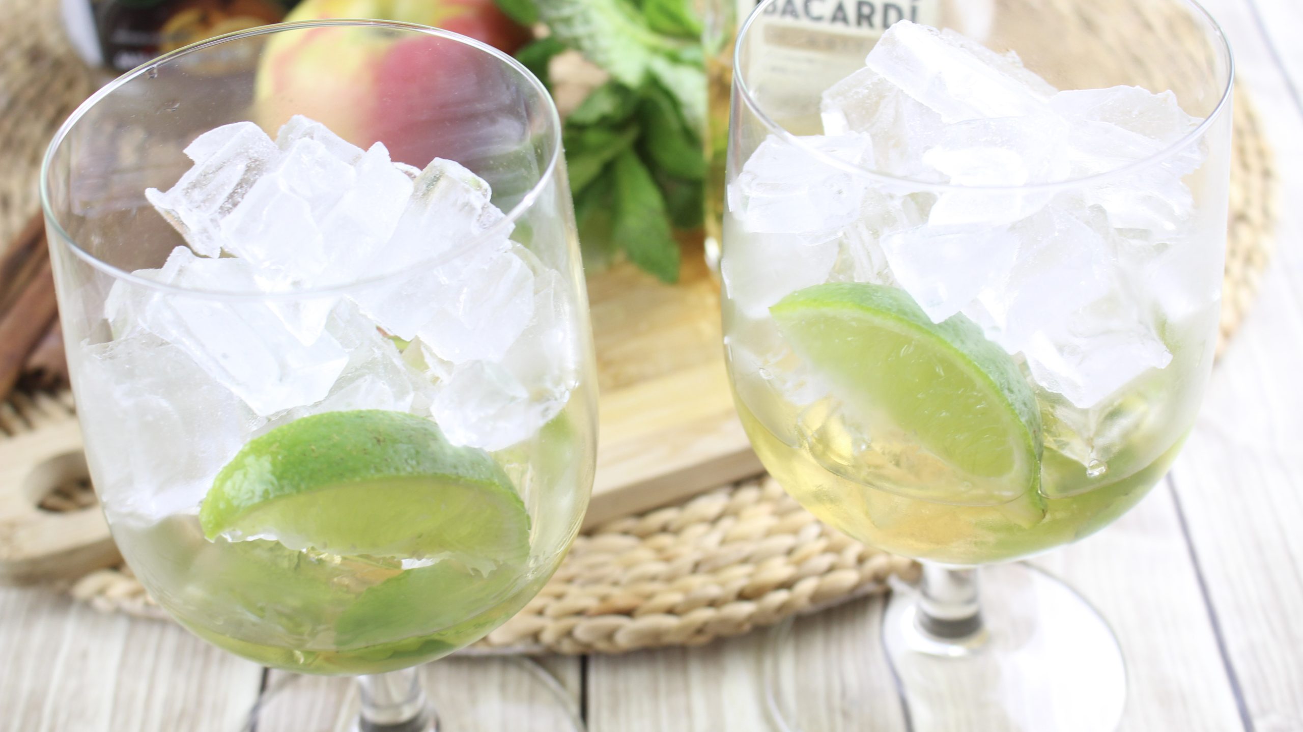 cocktail glasses filled with ice and lime