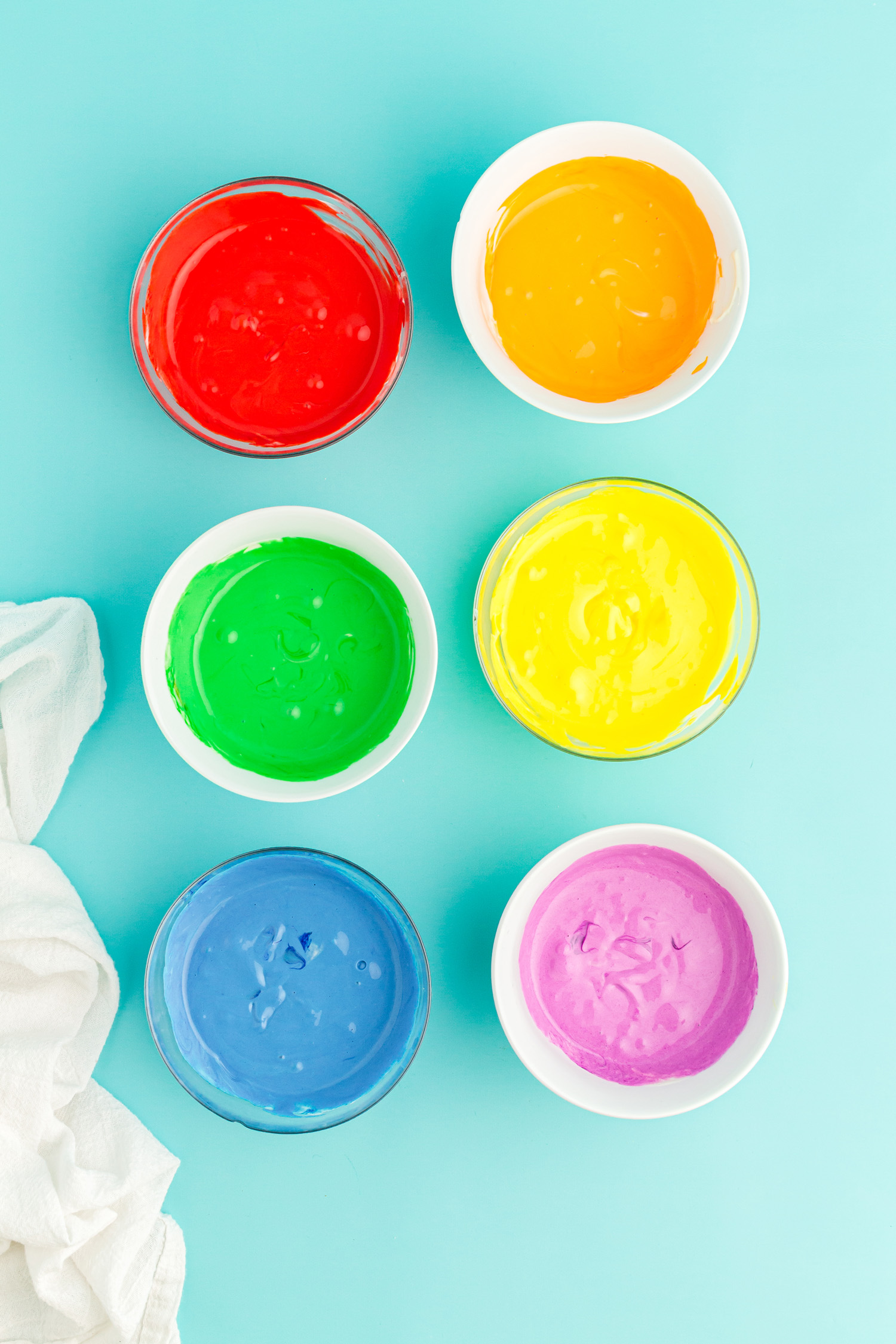 cheesecake ingredients in bowls, dyed in rainbow colors