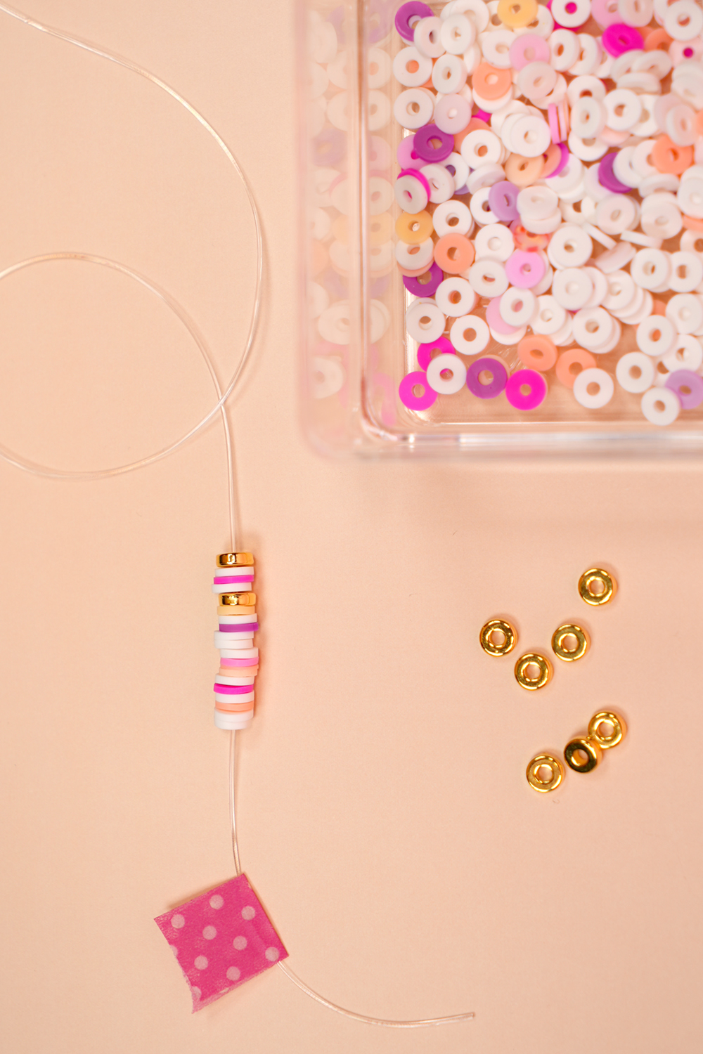 Close up of beading cord with beginning of bracelet beading pattern next to a dish of beads