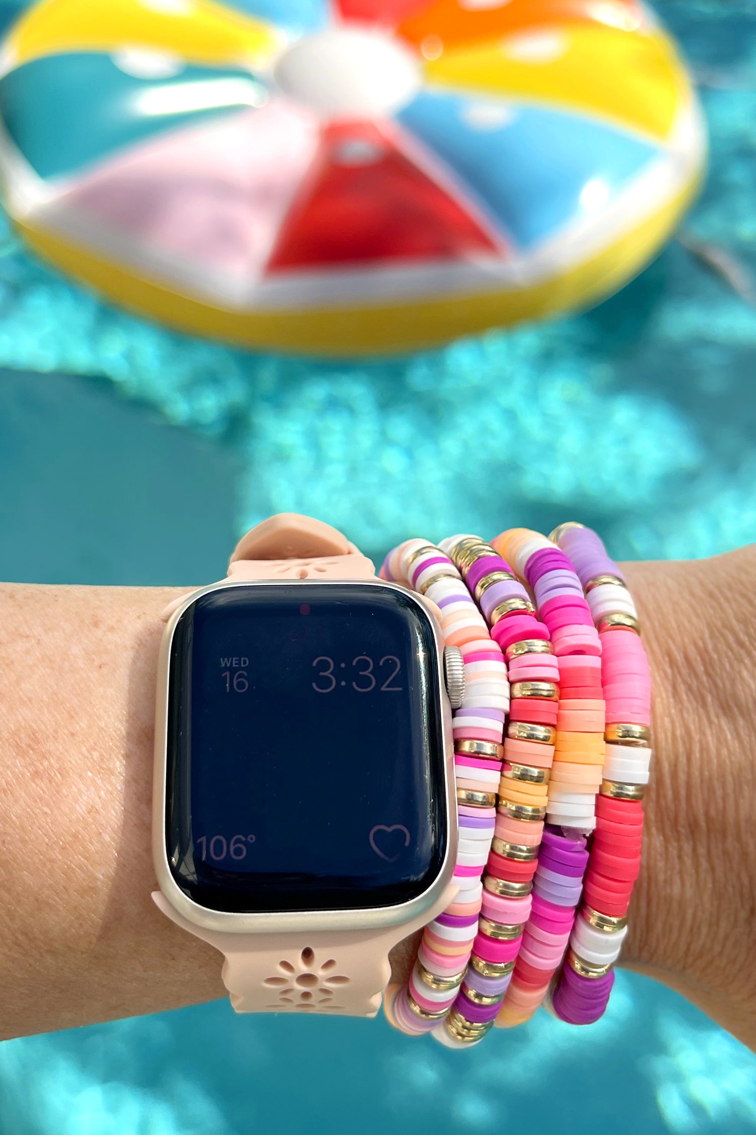 Colorful clay bead bracelets on wrist with watch by pool with floatie