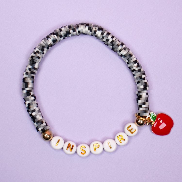 "Inspire" clay bead bracelet with black and white speckled beads and apple charm - "composition notebook" teacher bracelet - on purple background