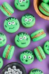 cute monster themed cookies- Frankenstein Halloween macarons on purple background