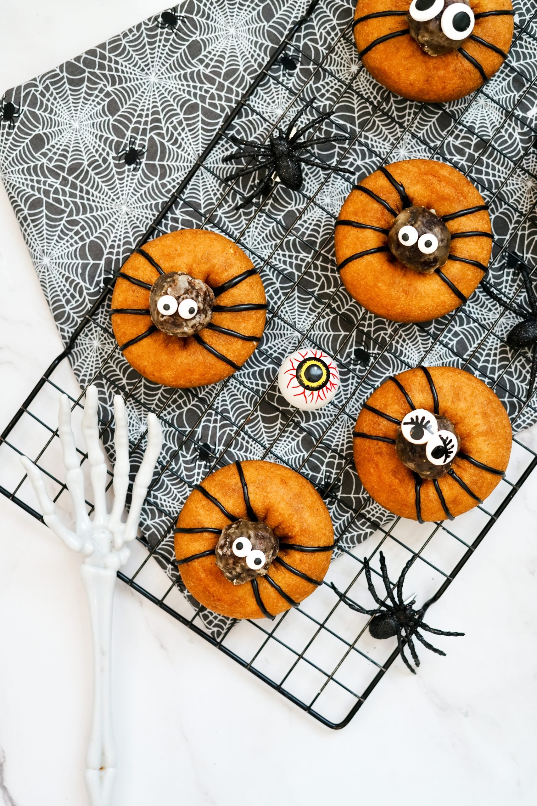 fun halloween desserts on tray with spiders and skeleton hand and eyeballs