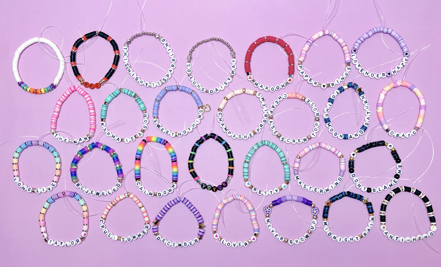 28 colorful beaded Taylor Swift Eras Tour friendship bracelets on a lavender background