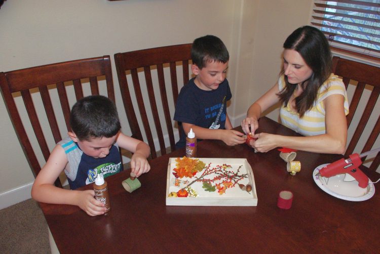 Children at a table glueing embellishments on napkin rings