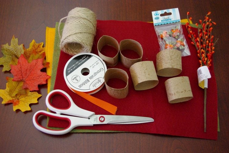 Scissors, cardboard tubes, and other craft materials on red felt