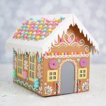 Cardboard gingerbread house with pastel rainbow faux candy decorations