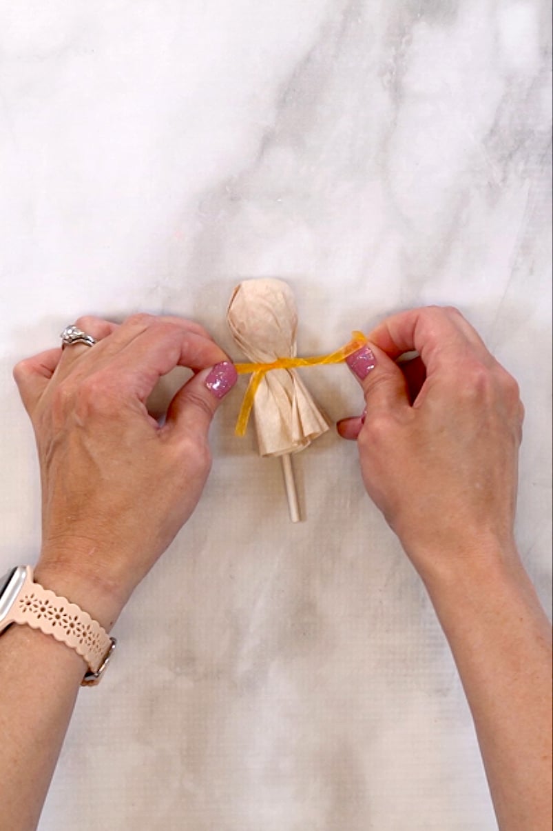 tying turkey lollipop head with a ribbon