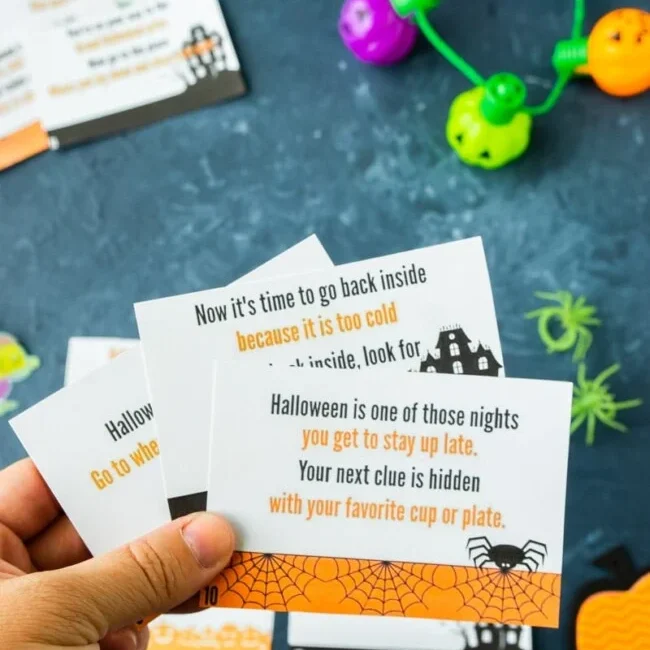 hand holding Halloween treasure hunt printable cards