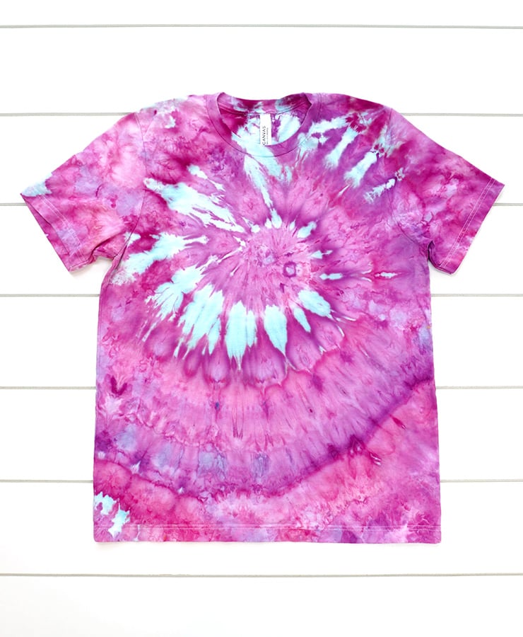 Pink, blue, and purple ice dyed spiral t-shirt on white wood background