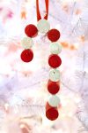 candy cane wine cork ornament hanging on white christmas tree