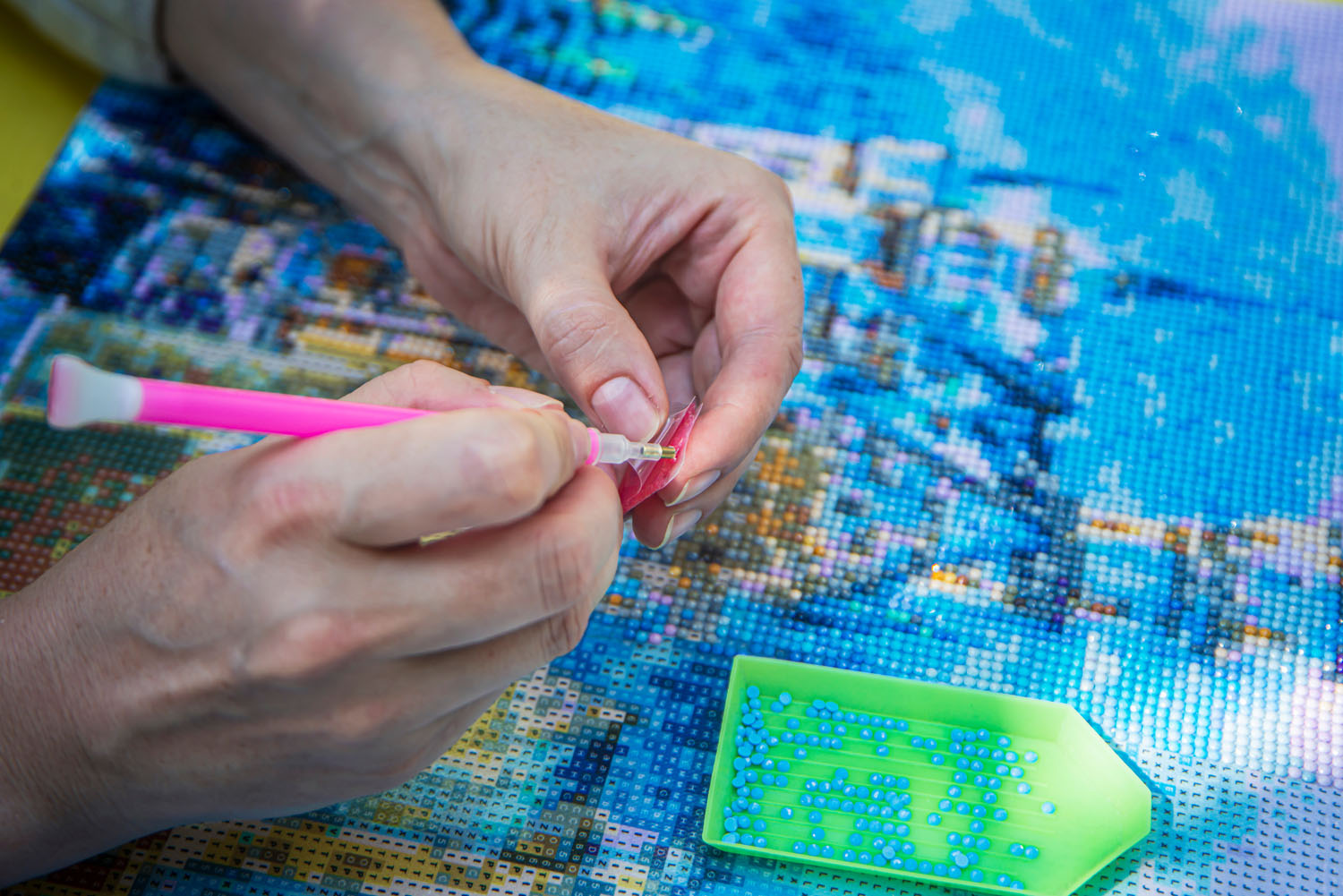 Close up of hands applying wax to a diamond painting pen