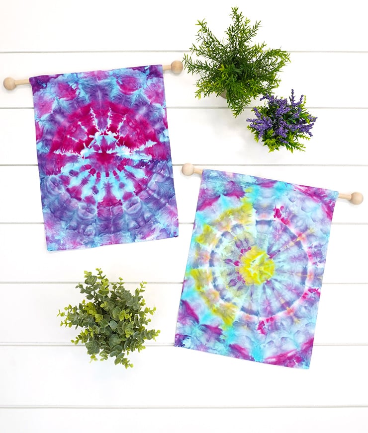 ice dyed garden flags on wood dowel hangers on white wood background with plants