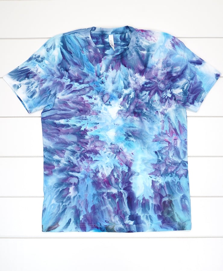 Ice dye t-shirt in varying shades of blue and purple with a very fluid, watercolor-like design pattern