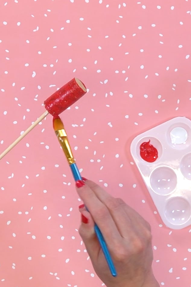 painting a wine cork red with paint tray nearby