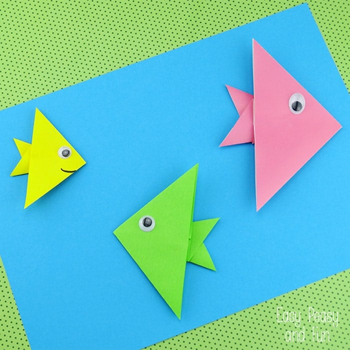 colorful origami folded fish on blue background