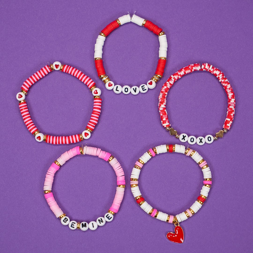 Five clay bead Valentine's Day beaded bracelets on a purple background