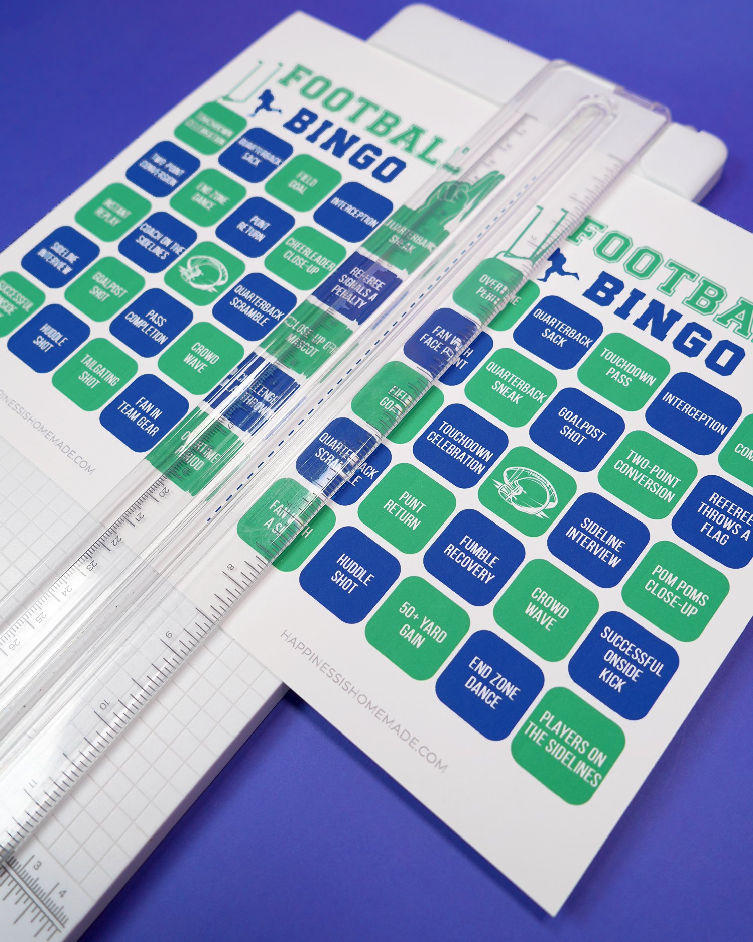Close up of paper trimmer cutting two football bingo cards