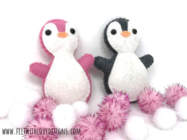 a pink and black and white penguin softie plushie with puff balls