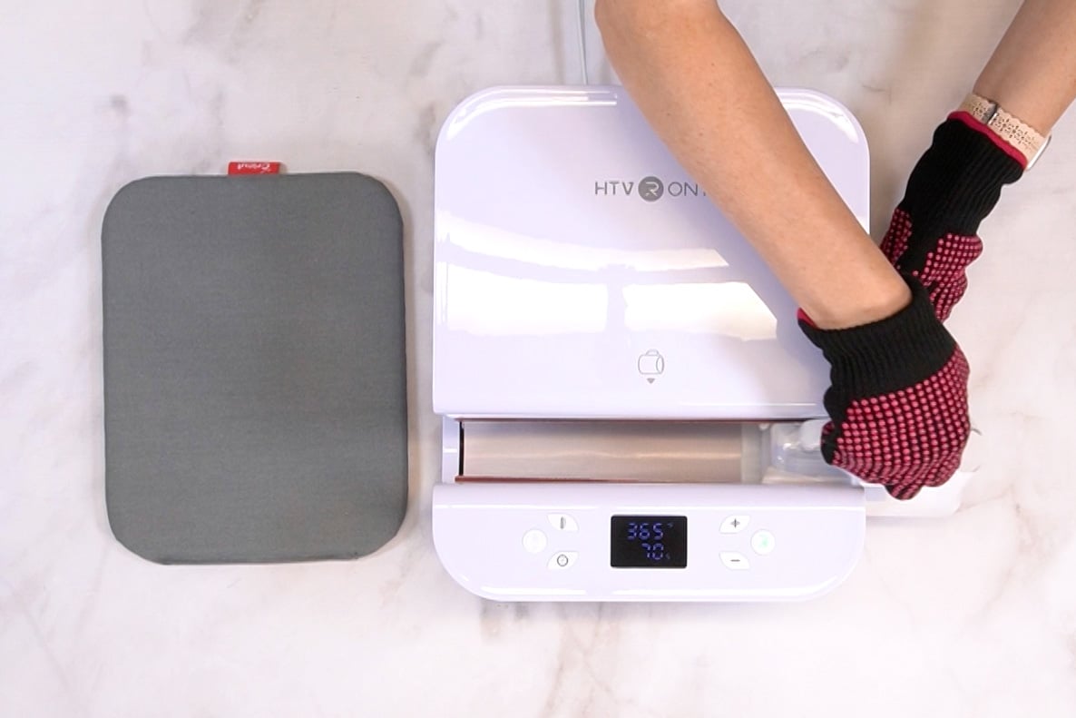 Overhead view of hands putting a ceramic mug into the HTVRONT Auto Tumbler Press