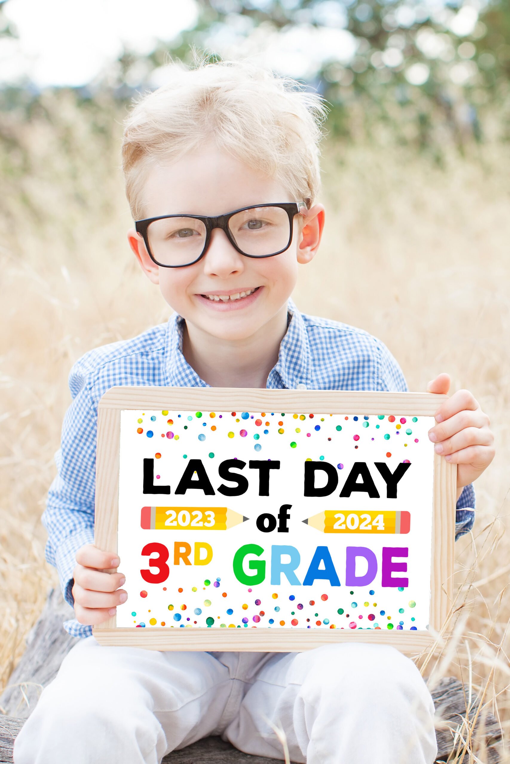 smiling schoolboy in glasses holding "Last Day of School 2024" sign