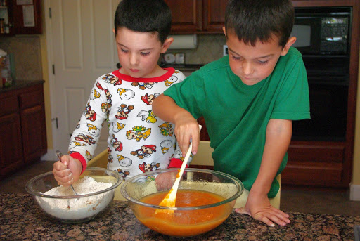 kids mixing together dry and wet ingredients for banana bread 