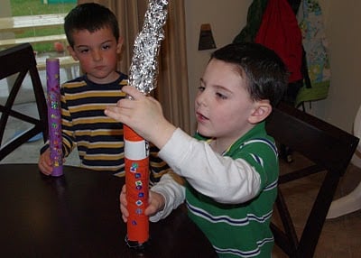 kids adding tin foil to rain sticks 