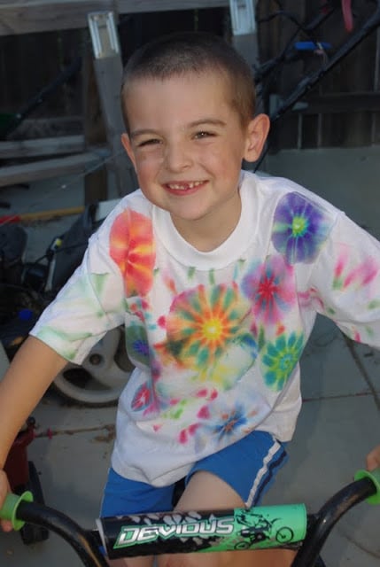 small smiling boy wearing neat homemade tie dye shirt 