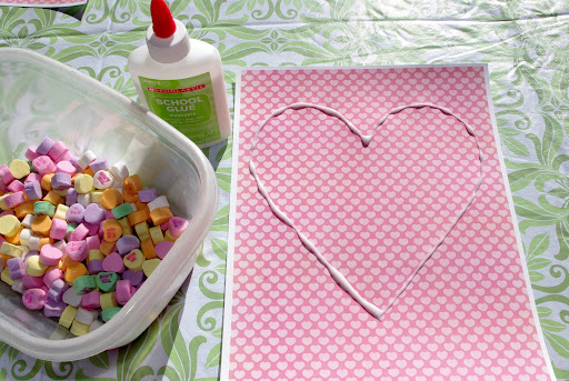 glue lined into heart shape on paper with bowl of conversation hearts nearby