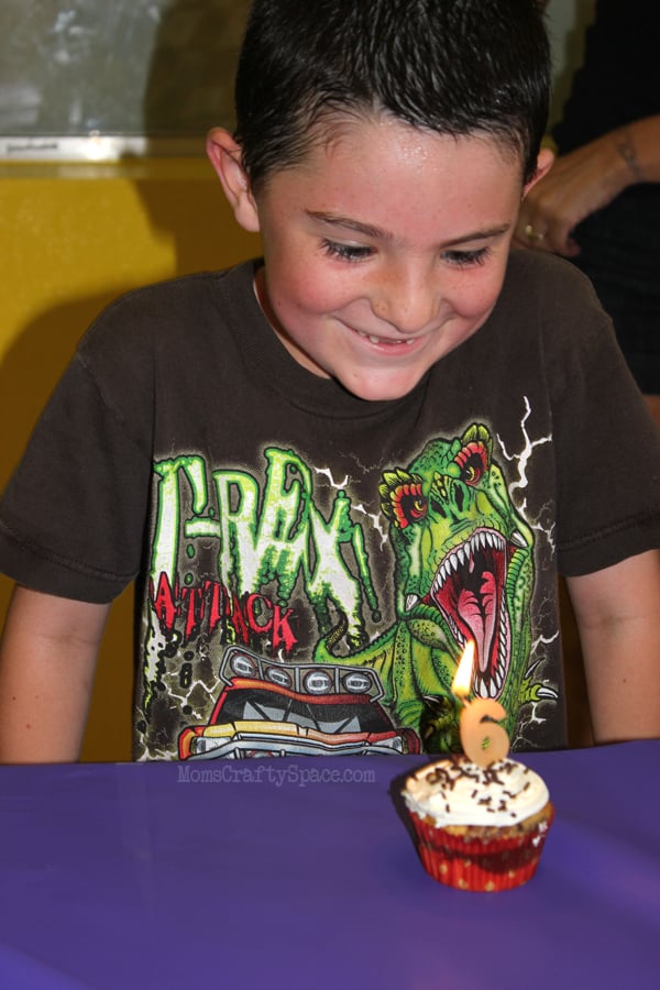child enjoying birthday party and blowing out candle for 6th birthday