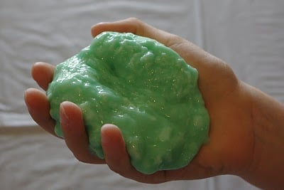 kids hand molding diy slime into ball