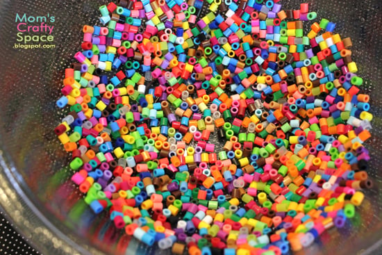 colorful perler beads added to bowl