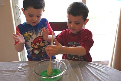 kids mixing up homemade slime recipe