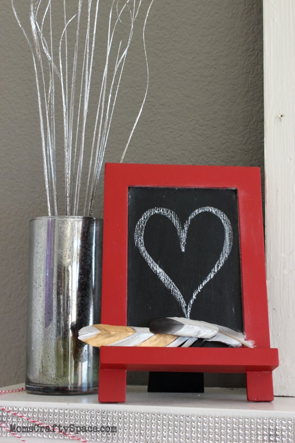 heart drawn on chalkboard with gilded feathers and vase 