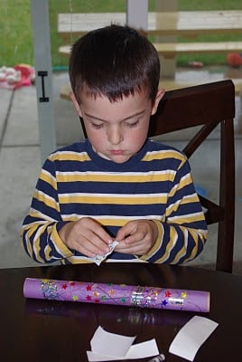 child adding stickers to diy rainsticks