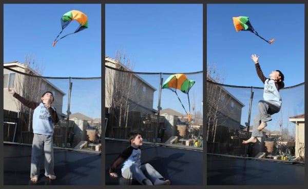 child jumping on trampoline with parachuting toy