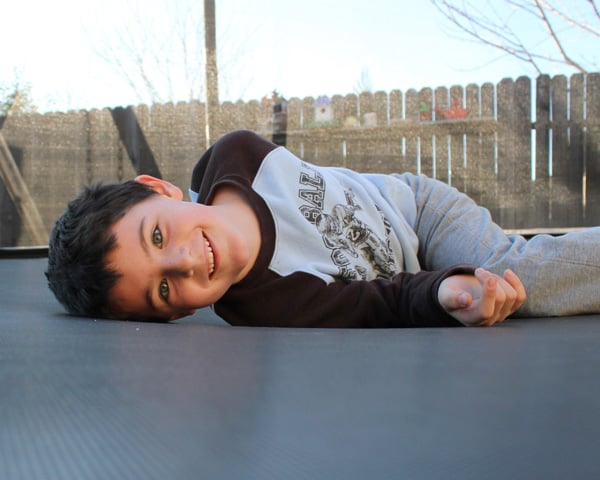 cute smiling boy lying on trampoline